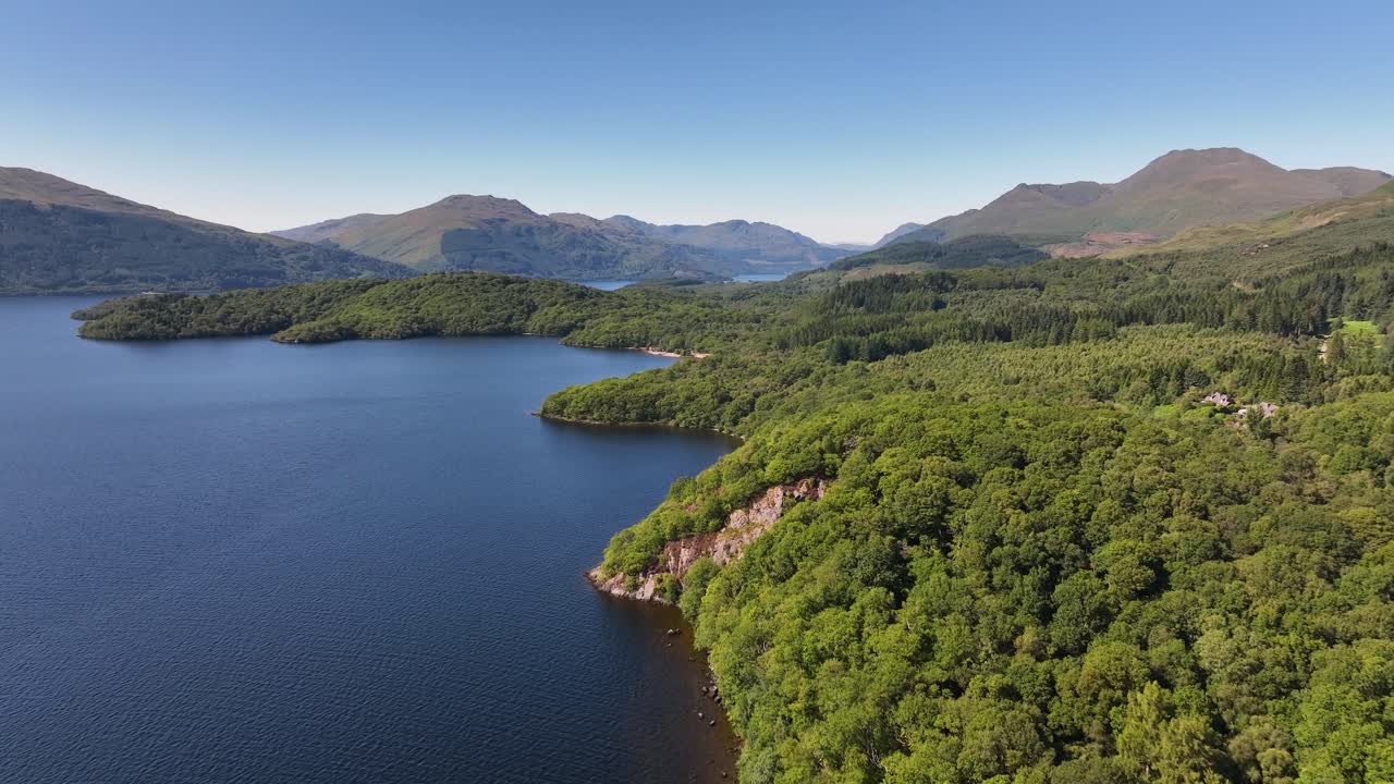 volando a lo largo del lado de la costa de loch lomond para levantar y revelar ben lomond y montañas cortas