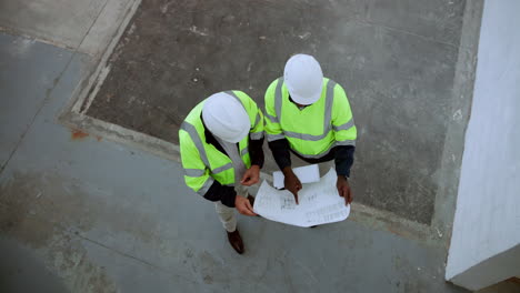 construction workers reviewing blueprints on site