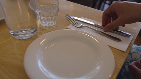 arranging cutlery and glass on table