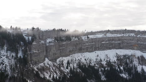 Aerial-of-snow-covered-mountain-ridge-and-forest