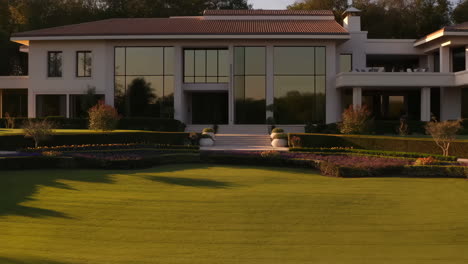 luxurious modern mansion with expansive lawn and landscaped garden