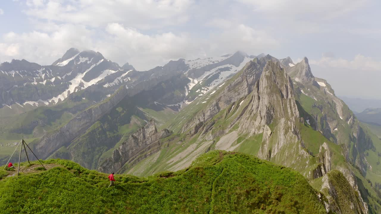 un hombre con una chaqueta roja camina sobre una montaña