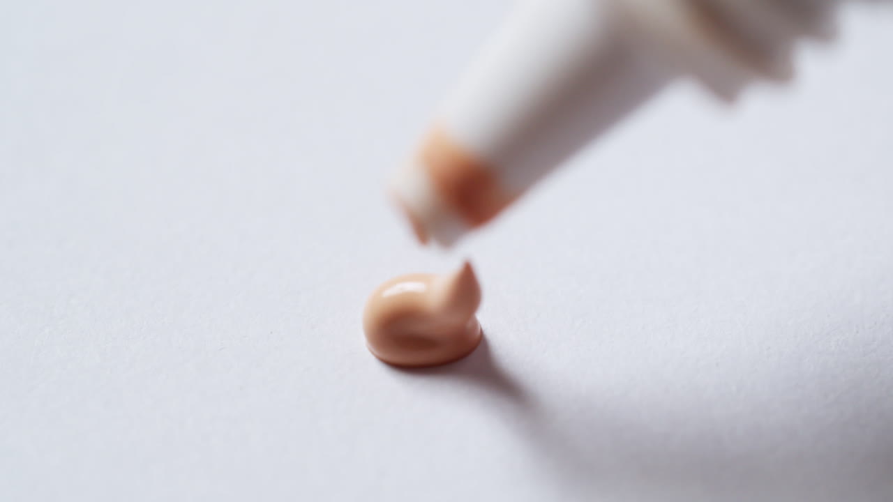 깨하고 색의 팔레트 보드에 플라스틱 튜브에서 완두콩 크기의 방수 액체 커슬러를 압축합니다.