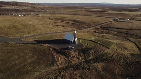 Lutheran-Church-Úthlíðarkirkja-in-Iceland,-aerial-backwards,-countryside-panorama