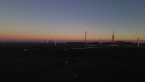 drone flying towards wind turbines on wind farm at dusk, valley of tears, israel
