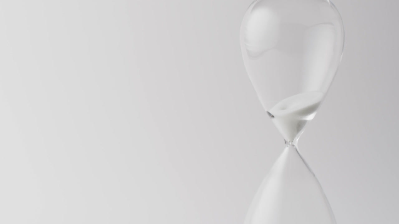 Video of hourglass with sand pouring, copy space on white background