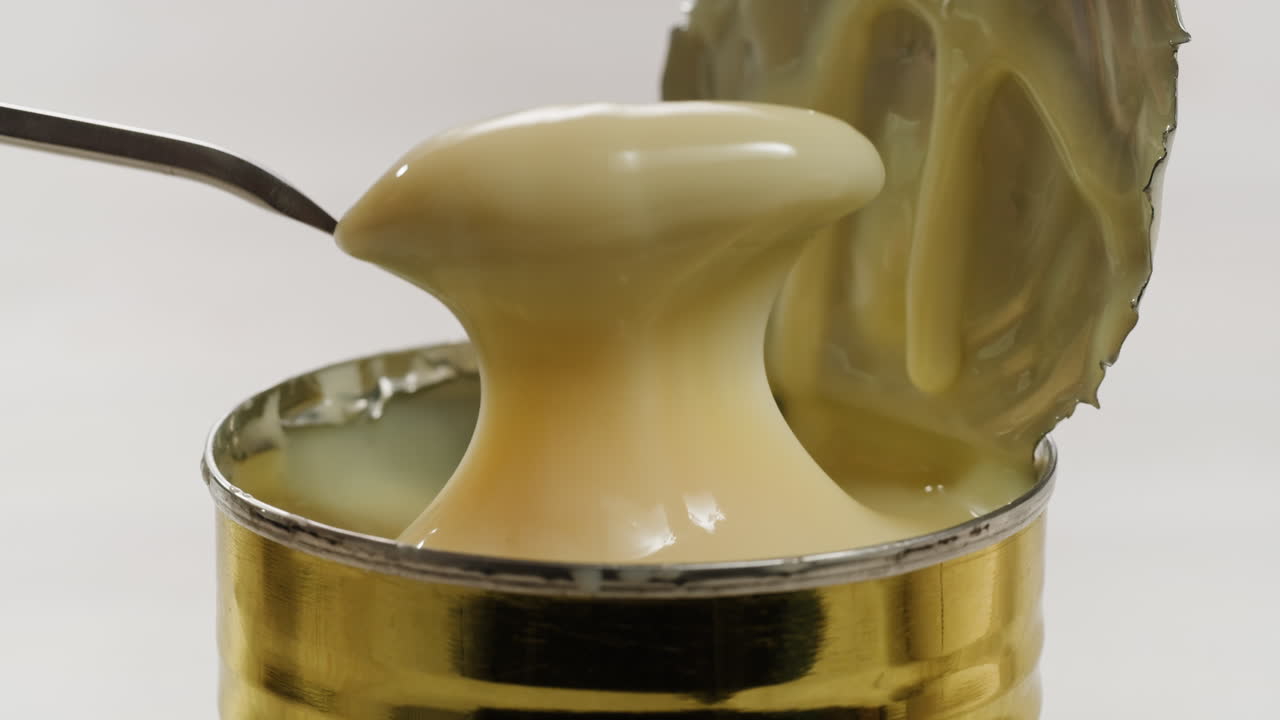 saborosa leche condensada, cuchara y waffles en la mesa gris claro, plana. espacio para el texto. imágenes de alta calidad 4k