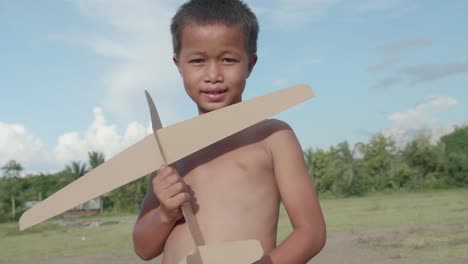 boy playing with a cardboard airplane