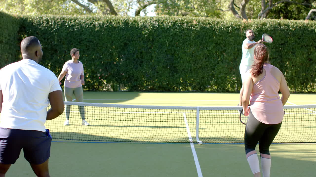 Playing tennis on outdoor court, Diverse Friends enjoying recreational activity together