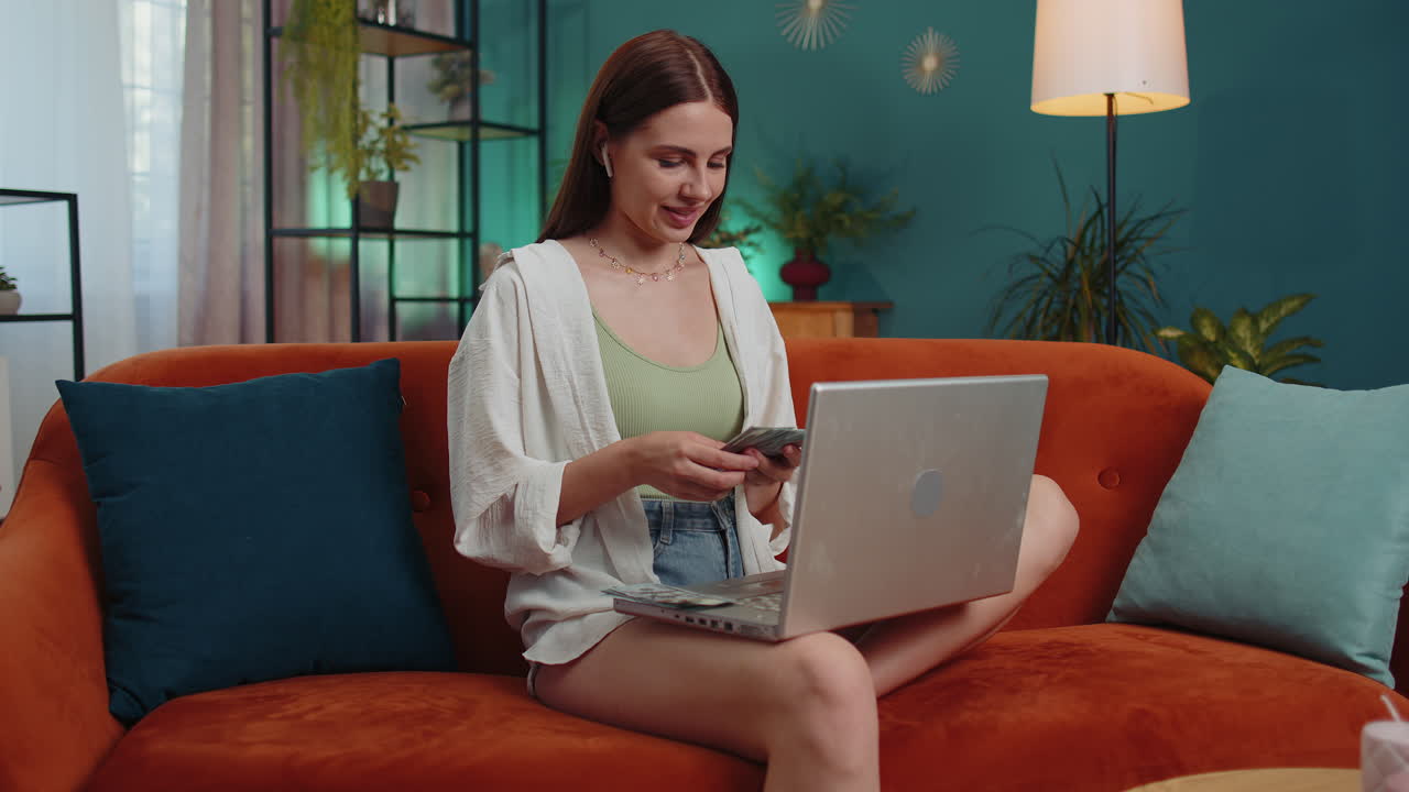 mujer sonriente feliz contando dinero en efectivo y usar computadora portátil calcular los ingresos domésticos ganancias en casa
