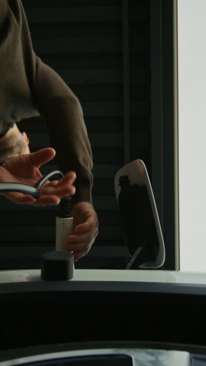 전기 차량을 충전하는 사람