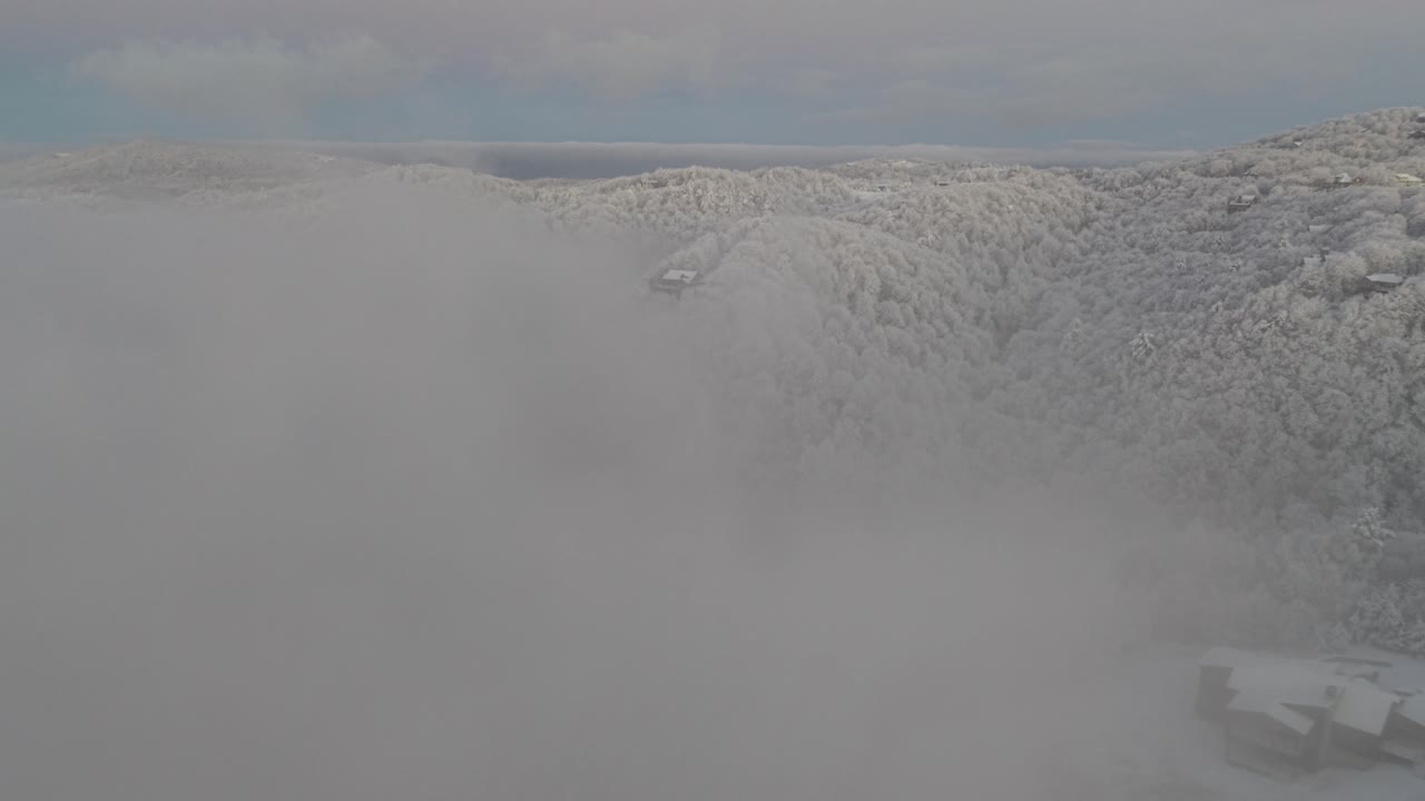 눈보라 후 구름 사이로 보이는 노스캐롤라이나주 분 근처의 눈 덮인 산