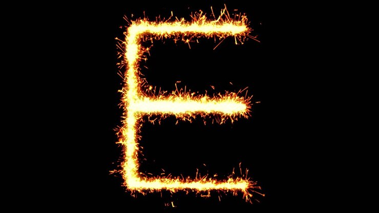 Scrittura con scintille della lettera E dell'alfabeto, con particelle glitterate e fuochi d'artificio su sfondo nero 4K in loop