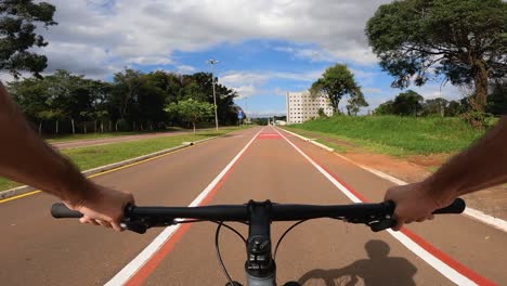 Cyclist-riding-on-a-bike-path-with-horizontal-signs-for-bicycle-and-joggers,-POV-shot