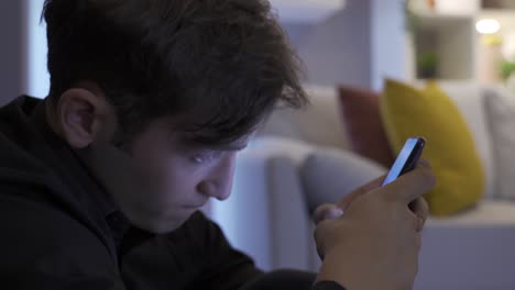 un joven frustrado enviando mensajes de texto por teléfono.