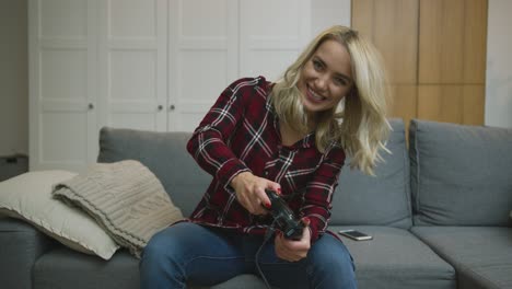 woman playing video game on sofa