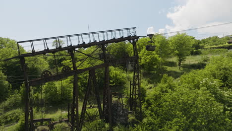 pilón oxidado del teleférico del cargo de la carga en la ladera cubierta en georgia