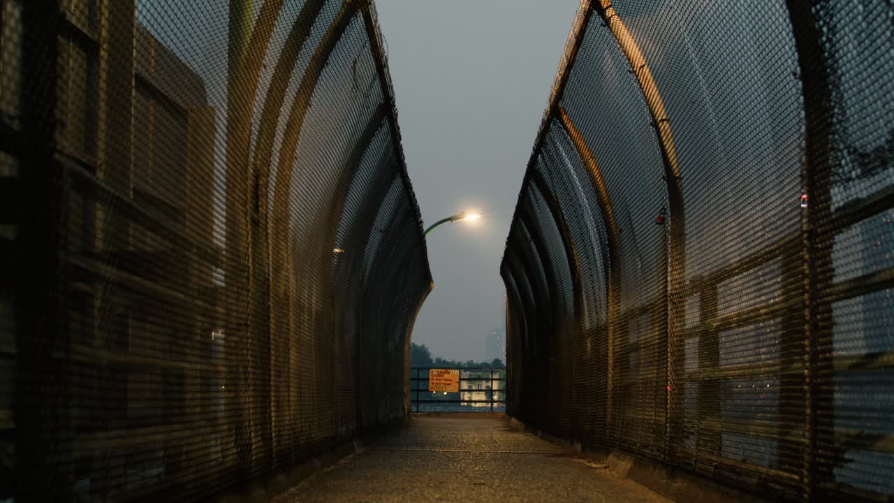 카메라가 동강의 보행자 통로에서 볼 수 있는 연기가 많은 뉴욕 시를 밀어 넣습니다.