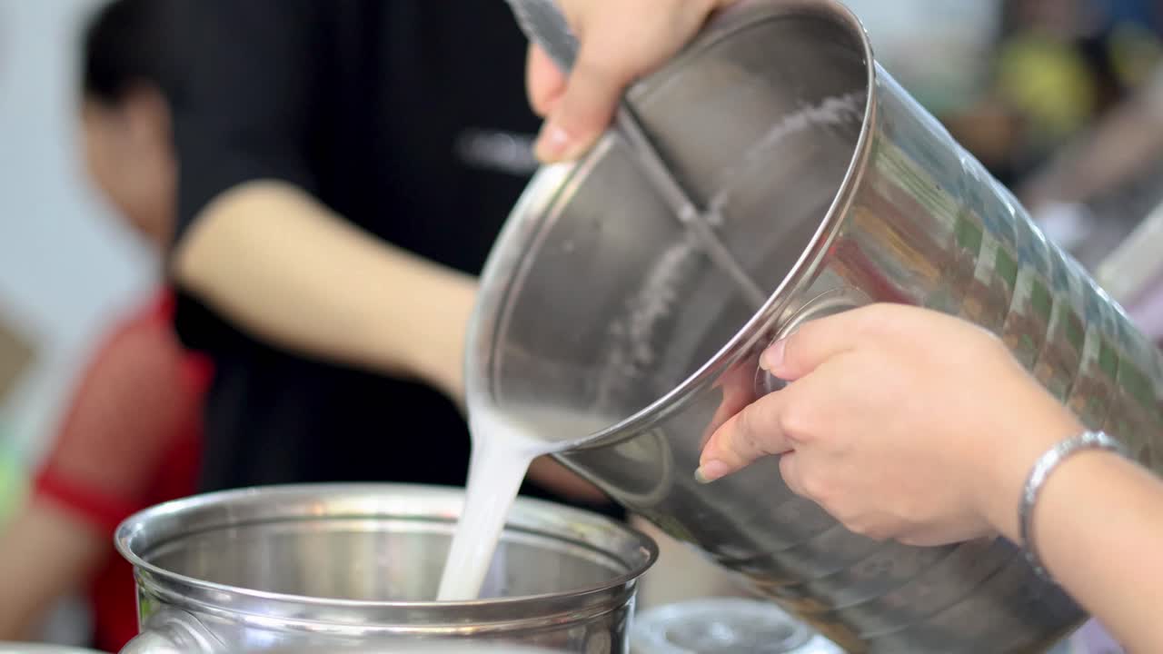 Mani che mescolano e versano ingredienti in una pentola