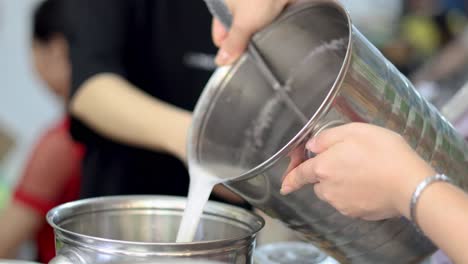 hands mixing and pouring ingredients into a pot