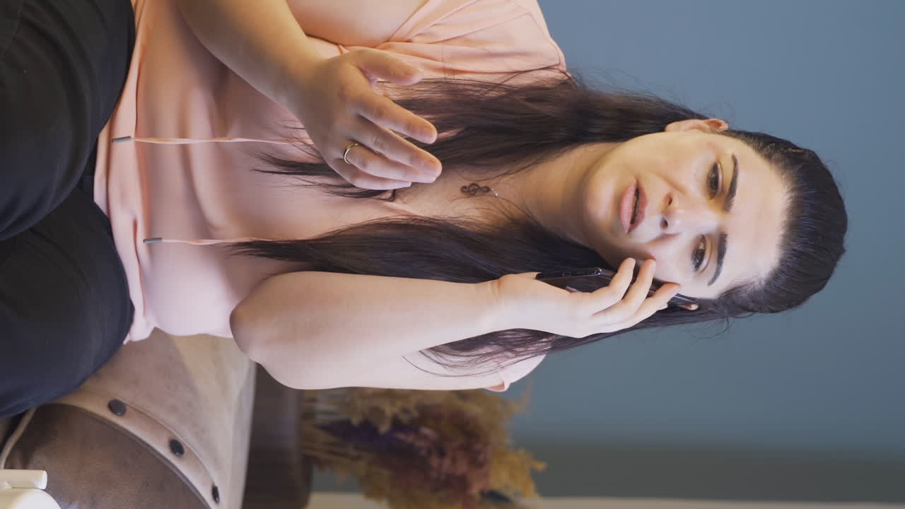 전화로 남편과 논쟁하는 여자의 수직 비디오는 그녀의 반지를 벗습니다.