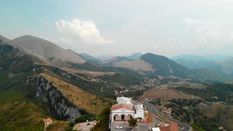 Aerial-Dolly-In:-Drohne-Fliegt-In-Richtung-Einer-Typischen-Kleinen-Italienischen-Kirche-In-Einem-Extremen-Aufbau-Auf-Der-Spitze-Eines-Isolierten-Hügels,-Umgeben-Von-Einer-Unglaublichen-Aussicht-Auf-Die-Berge-Im-Süden-Italiens,-Maratea-Basilicata