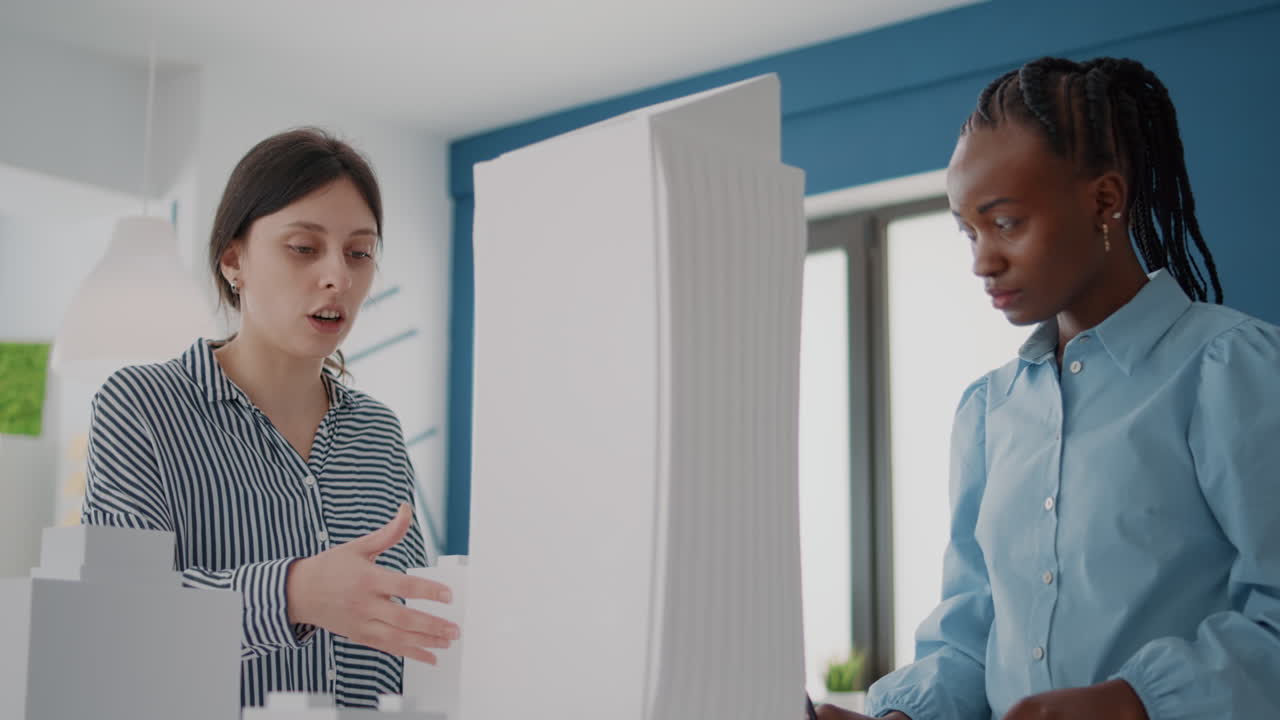 Two businesswomen discuss plans in startup office