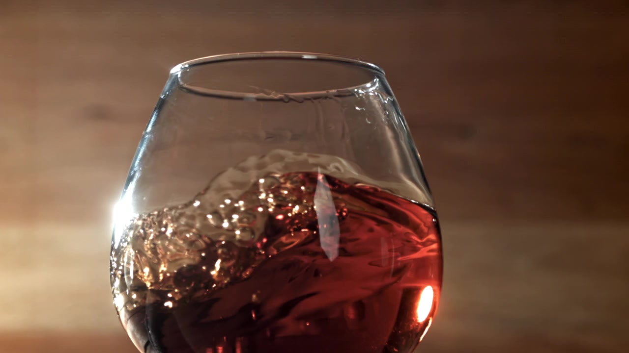 Vino rosso che volteggia in un bicchiere al rallentatore