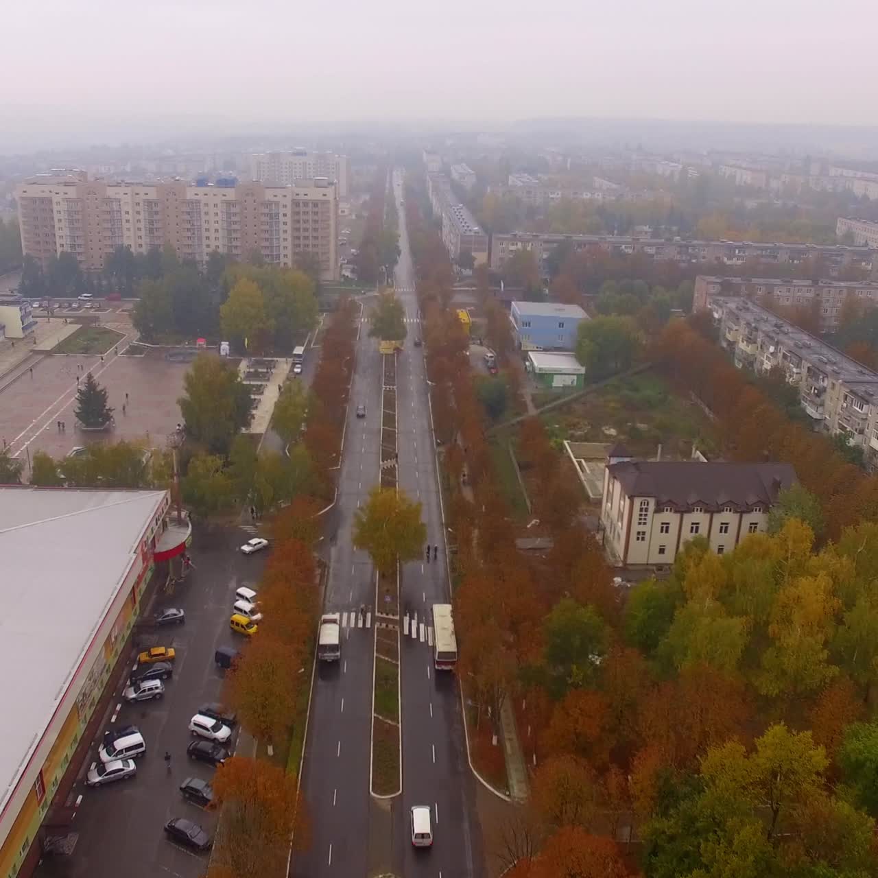 Two parallel straight roads crossing the city. Drone footage over the motorway up to a crossroads. Autumn city background