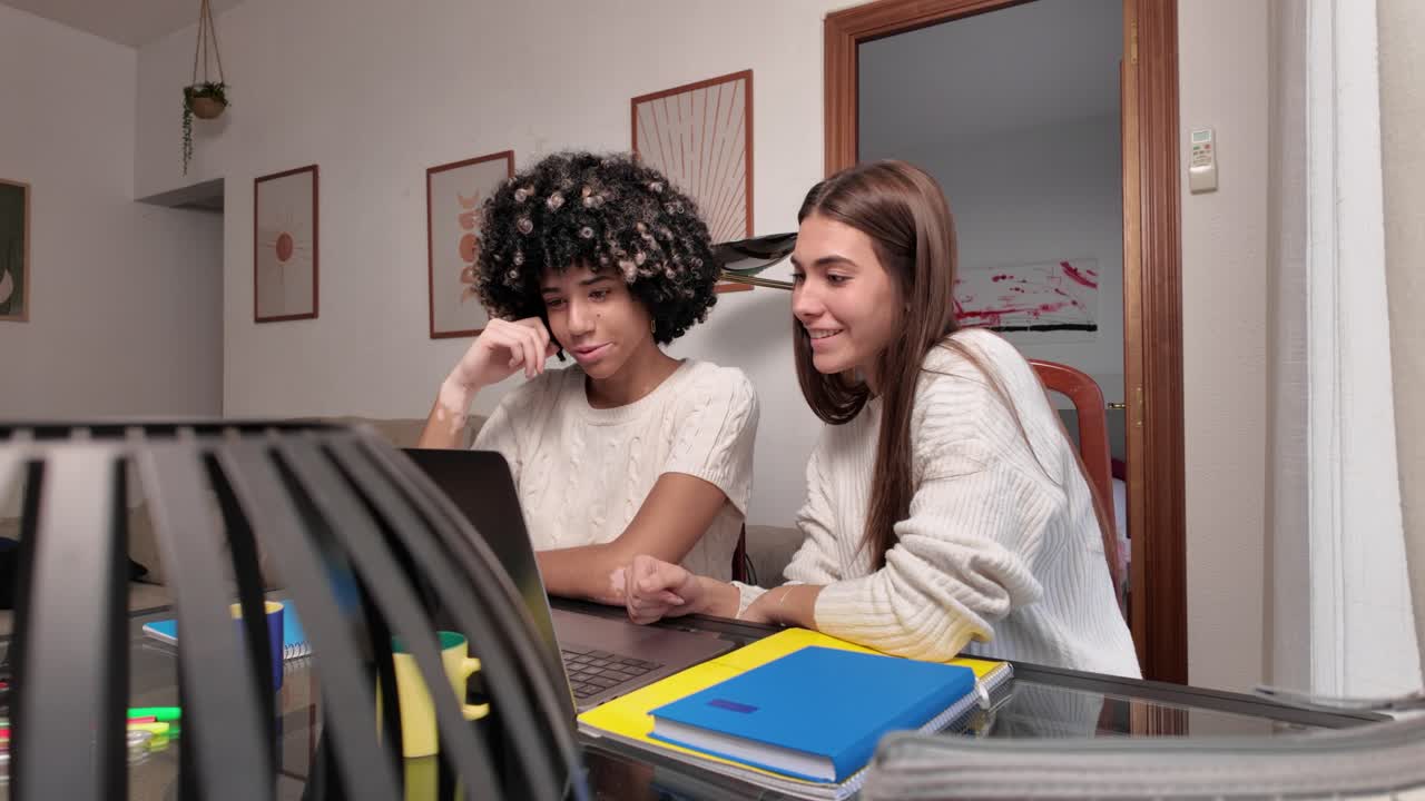 Two young women studying together at home