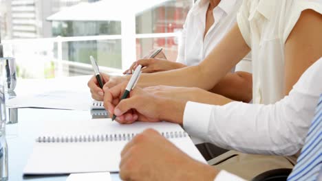 business people taking notes during a meeting