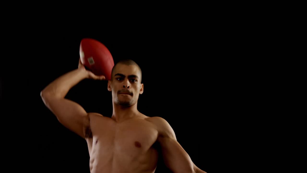 미국 축구 선수가 검은 바탕 4k에 공을 던지고 있습니다.