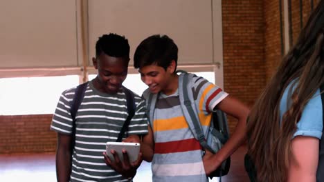 Glückliche-Studenten,-Die-Auf-Dem-Campus-Mobiltelefone-Und-Digitale-Tablets-Nutzen