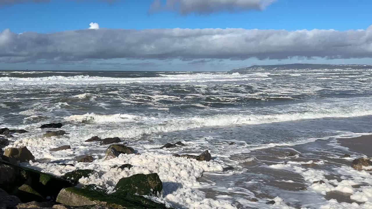 Onde marine che si infrangono con forza sulla riva in inverno