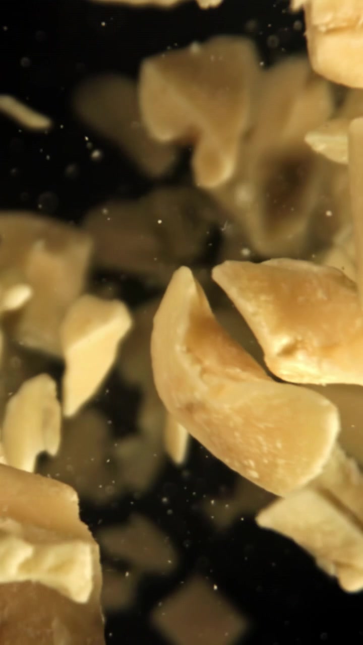 Ripresa Macro di Pezzi di Cibo Beige che Cadono al Rallentatore