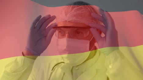 German-flag-waving-against-male-scientist-wearing-protective-glasses