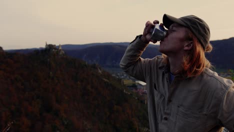 person drinking from coffee pot looking to spectacular landscape, vogelberg