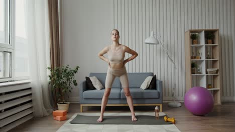 mujer joven estirándose y practicando yoga en casa