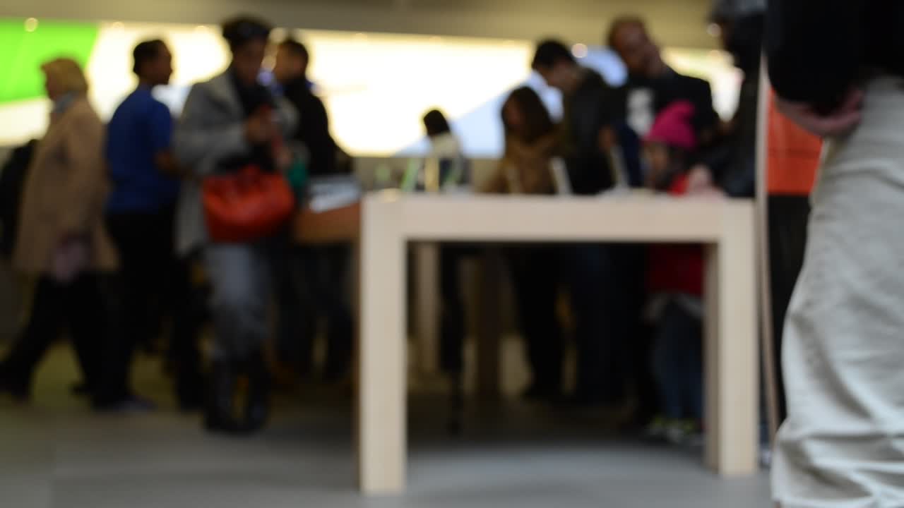 Pembeli di toko, buram. New York, AS. Orang-orang tak dikenal di Apple Store 5th Avenue, New York, Manhattan