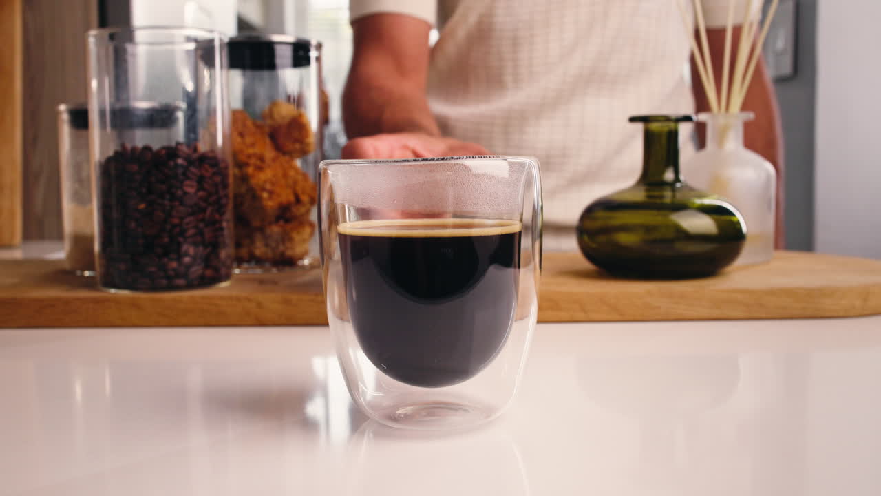 Persona che tiene in mano una tazza di caffè appena fatto