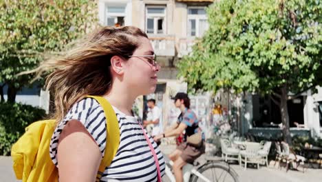 woman in motion walking through a city on a sunny day, athens, greece