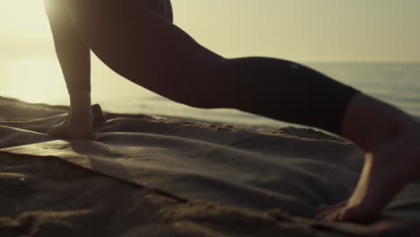 unknown bare woman legs stretching on beach closeup. girl feet stand yoga pose.