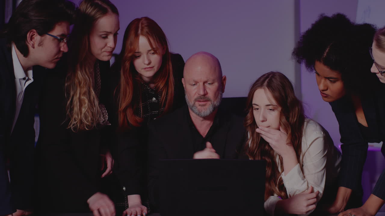 Diverse Business Team Collaborating Around a Laptop