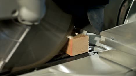 close-up of a man's hand working on a machine with a circular saw