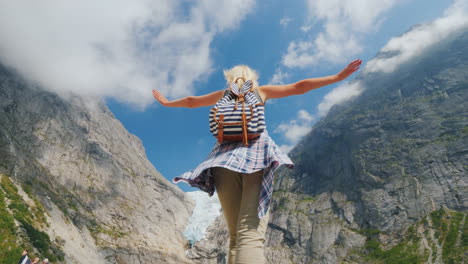 A-Healthy-Woman-Raised-Her-Hands-Joyfully-Standing-On-The-Background-Of-The-Brixdal-Glacier-In-Norwa