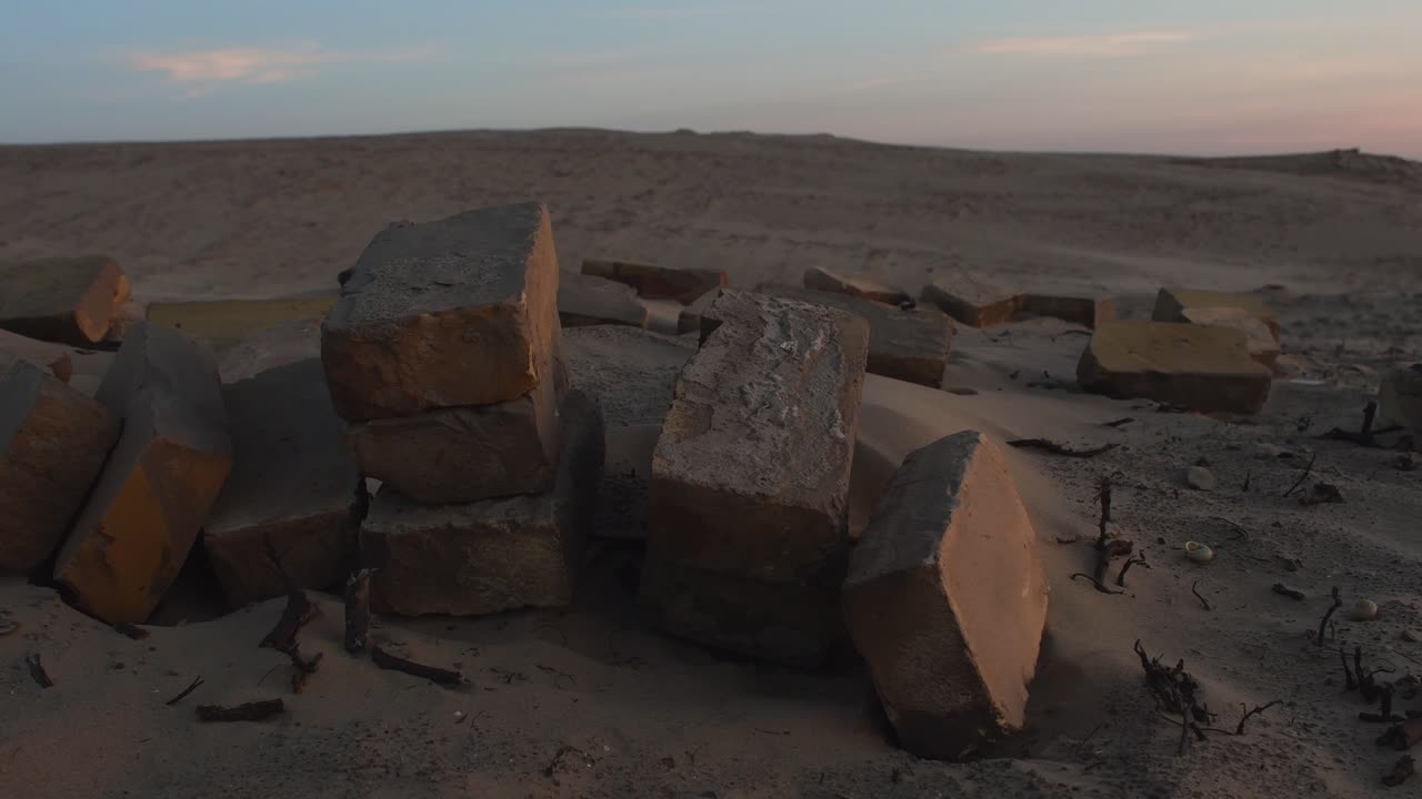 Static shot of old rocky bricks in desert during golden hour. Beautiful landscape with blue sky in dusk.