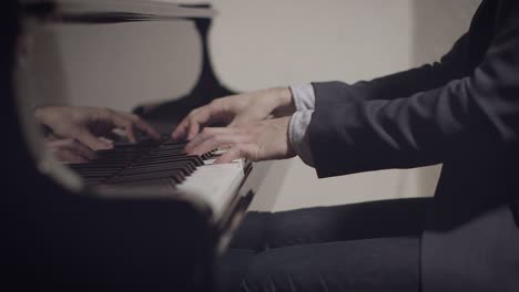 male pianist performing a song on piano with low light and shallow depth of field with slider motion