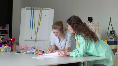 two dressmakers working in their studio.