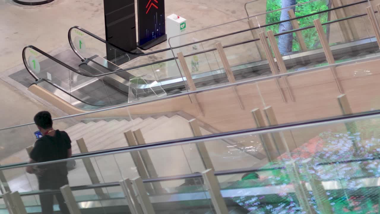 조용한 쇼핑몰에서 에스컬레이터를 내려가는 개인