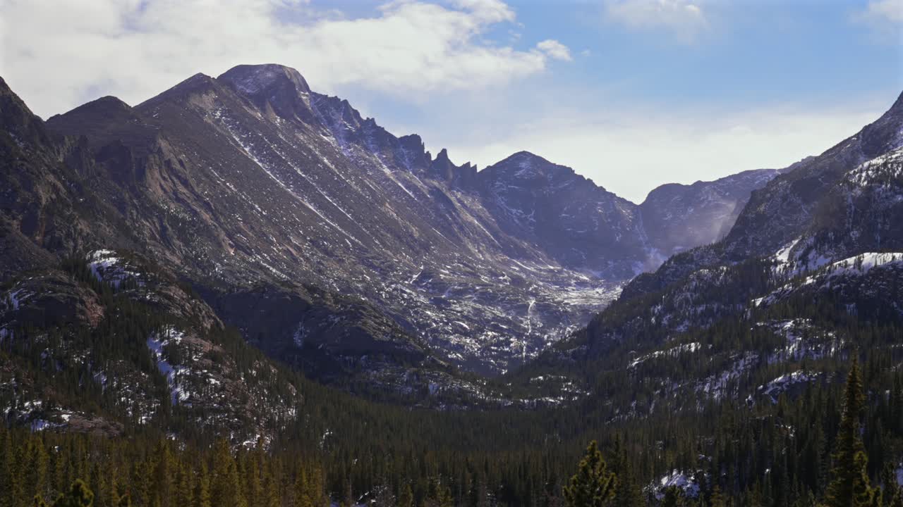 Parco Nazionale delle Montagne Rocciose in inverno, Longs Peak, Colorado. Cielo azzurro e soleggiato, nuvole. Paesaggio naturale di Estes Park. Inizio sentiero del Lago Bear, vista del Lago Smeraldo. Neve che soffia, vento, campo di massi. Scatto statico.